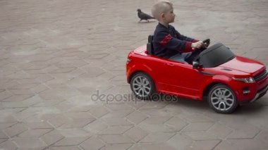 Çocuk üzerinde kırmızı bir oyuncak Araba sürme