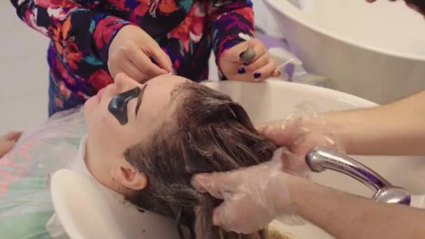 Девушка моет голову и раскрашивает брови — стоковое видео