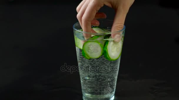 Ruka vytáhne sklenice vody okurky — Stock video