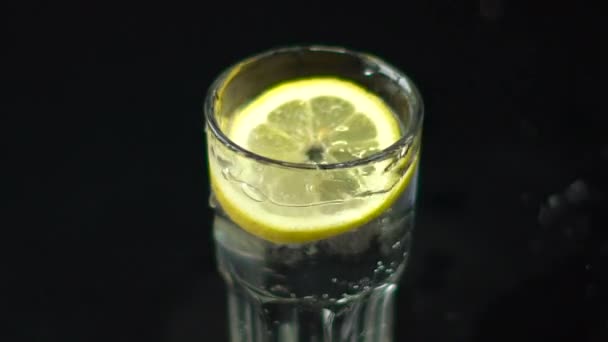 Rebanada de gotas de limón en un vaso de agua — Vídeos de Stock