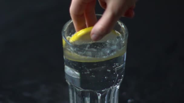 Main obtient une tranche de citron dans un verre d'eau 