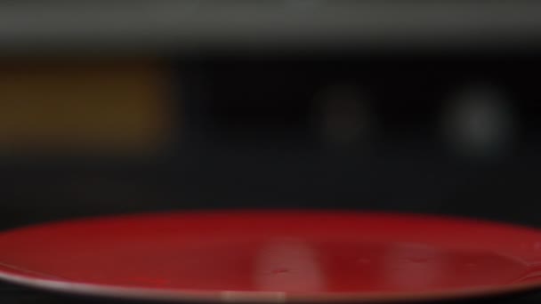 Грейпфрутовые слайсы падают на красную тарелку — стоковое видео