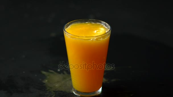 Une tranche d'orange dépose un verre de jus — Video