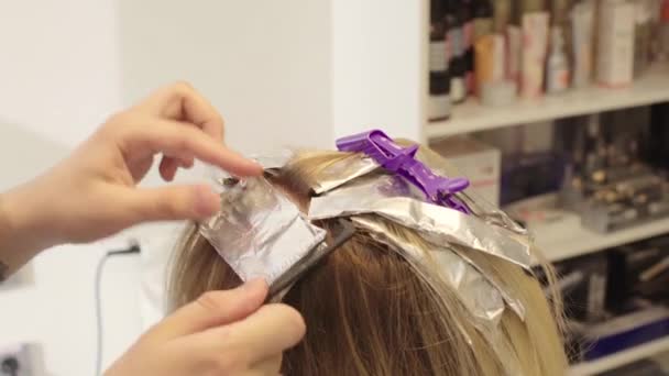 Професійний перукар, знебарвлення волосся дівчини — стокове відео
