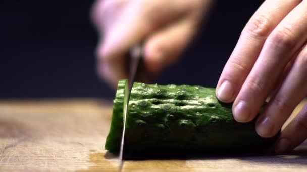 Женщина режет огурец на кухне — стоковое видео