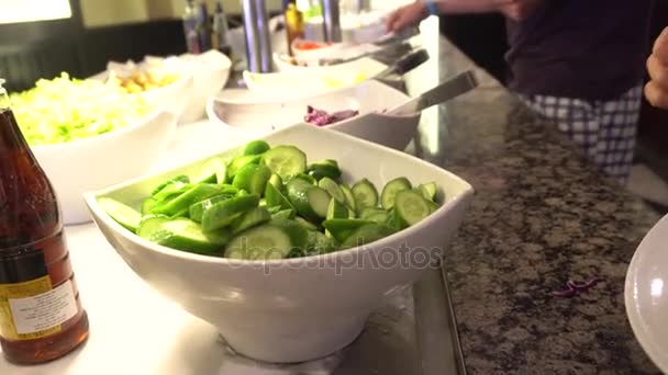 Kadın taze salatalık bir tabağına koyuyor. — Stok video