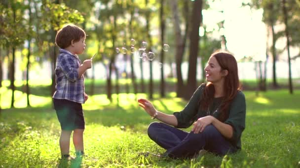 Figlio soffiando bolle di sapone con la mamma — Video Stock