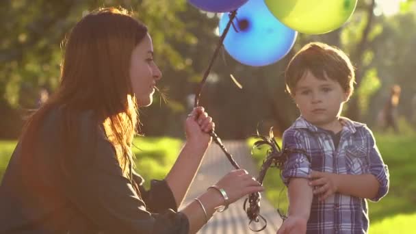 Jongen met ballonnen met zijn moeder — Stockvideo