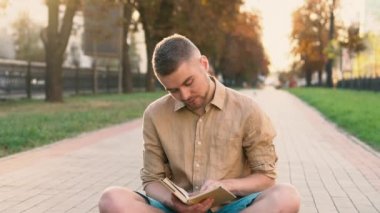 Genç adam parkta kitap okumak