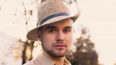 hasır şapkalı adam kameraya vardır