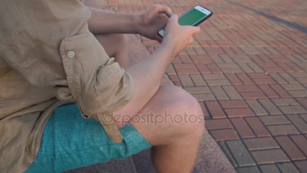 Hombre sosteniendo un smartphone en las manos de una pantalla verde pantalla verde — Vídeos de Stock