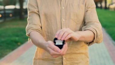 Bir kutu nikah yüzüğü 4 k ile tutan genç bir adam