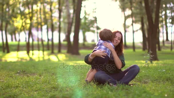 Feliz madre abrazando a su hijo en el parque, cámara lenta — Vídeos de Stock
