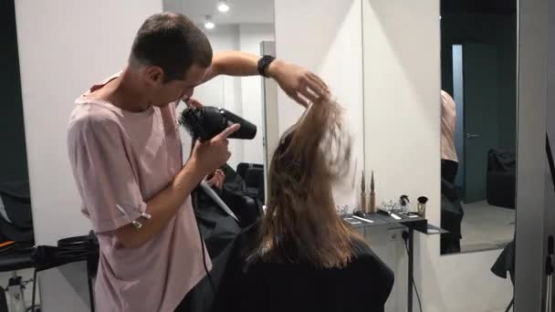 Mannelijke stylist met een haardroger. Kapper met een föhn. Stapelen. Kapper op het werk. Beauty Salon — Stockvideo