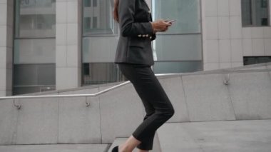 Modern akıllı telefonu elinde tutan genç bir iş kadını.