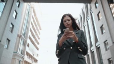 Genç yetişkin iş kadını modern akıllı telefondan mesaj yazıyor.