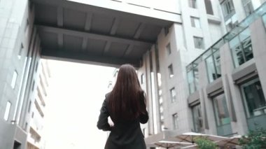Yetişkin bir iş kadını şehirde aletlerle yürüyor.