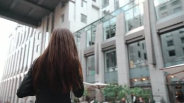 Şehirde akıllı telefondan konuşan genç bir iş kadını.