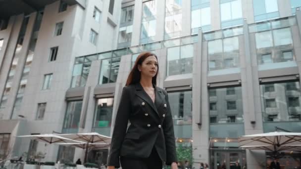 Junge erwachsene Geschäftsfrau zu Fuß in der Nähe des Geschäftszentrums — Stockvideo