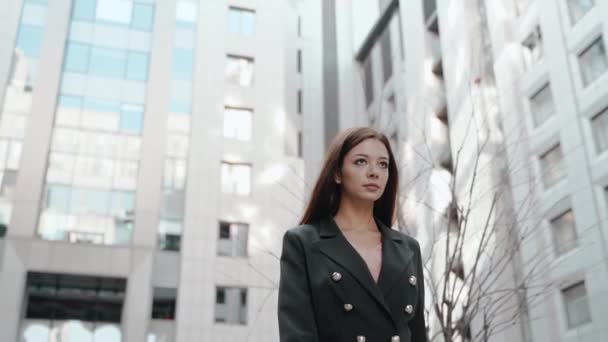 Young adult businesswoman walking near business center with calm face — Stock Video