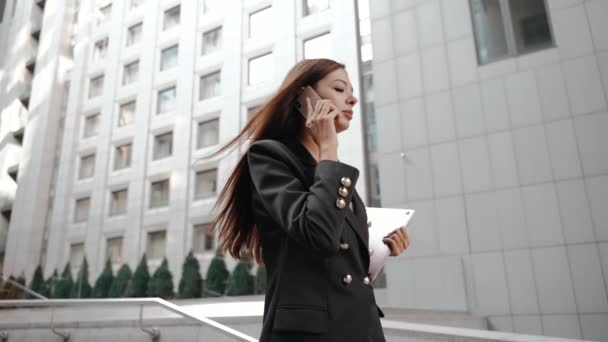 Joven mujer de negocios adulta hablando en el teléfono inteligente, portátil celebración — Vídeos de Stock