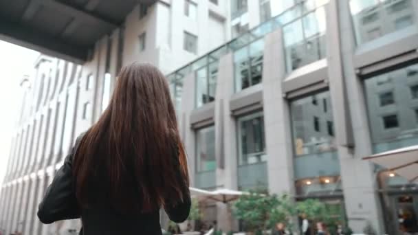 Young adult businesswoman talking on smartphone in city — Stock Video