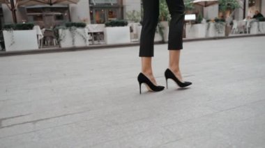 Kulaklıklı genç bir iş kadını dizüstü bilgisayar tutuyor.