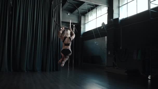 Joven adulto hembra usando aro aéreo, girar alrededor en circo — Vídeos de Stock