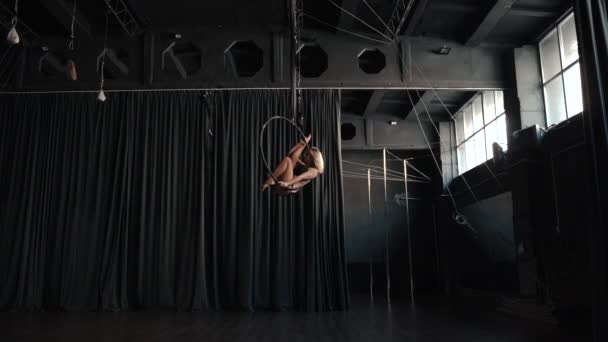 Jeune femme adulte utilisant cerceau aérien, faire son exercice de flexibilité — Video