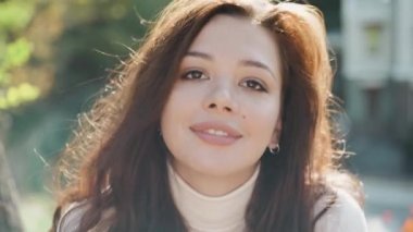 Genç yetişkin model kameraya bakıyor ve 4K şeklinde gülümsüyor.