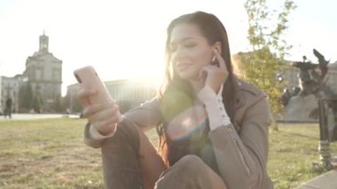 Parkta modern akıllı telefon kullanan genç bir kadın.