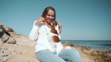 Küçük köpekle oynayan genç bir kadın.