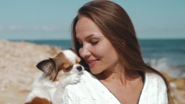 Genç yetişkin bir kadın hafta sonunu küçük bir köpekle geçiriyor.