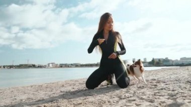 Genç yetişkin atletik kız köpekle boş zaman geçiriyor.