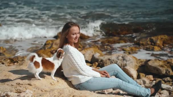 Jong volwassen meisje spelen met weinig huisdier op strand — Stockvideo