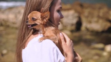Genç yetişkin bir kadın yaz gününü küçük bir chihuahua ile geçiriyor.