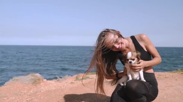Молодая взрослая женщина проводит свободное время на открытом воздухе вместе с домашним животным — стоковое видео