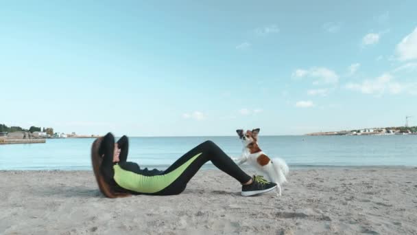 Young adult sports person training with little dog outdoor — Stockvideo