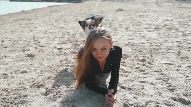Joven adulto deportista jugando con poco perro al aire libre — Vídeo de stock