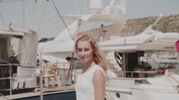 Young adult female in casual white dress walking near sea — Stock Video