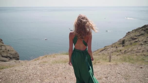 Молодая женщина проводит день на свежем воздухе в зеленом платье — стоковое видео