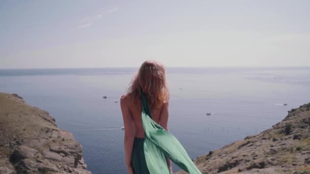 Молодая взрослая женщина стоит на улице в изящном зеленом платье — стоковое видео