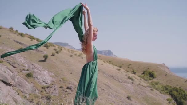 Jong volwassen vrouw brengen dag buiten in groene jurk — Stockvideo
