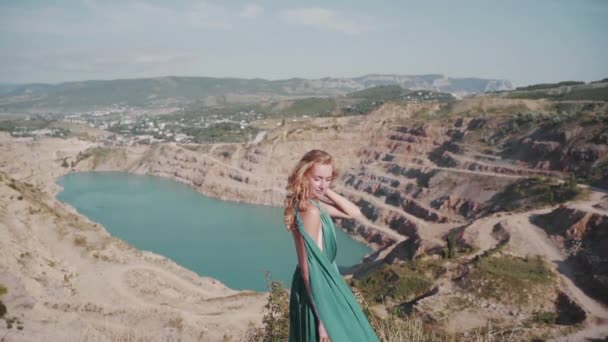 Młoda dorosła kobieta stojąca na zewnątrz w eleganckiej zielonej sukience — Wideo stockowe