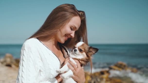 Young adult woman playing with little pet on beach — ストック動画