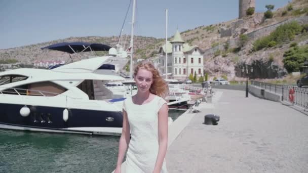 Młoda dorosła kobieta chodzenie w pięknej białej sukience — Wideo stockowe