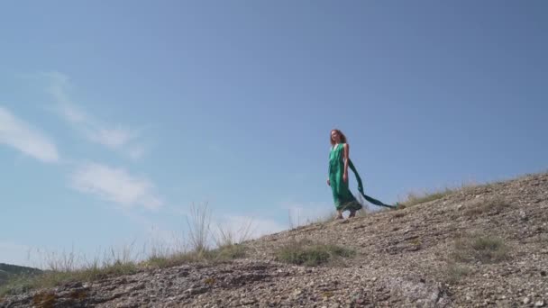 Menina adulta jovem em pé na colina em vestido verde na moda — Vídeo de Stock