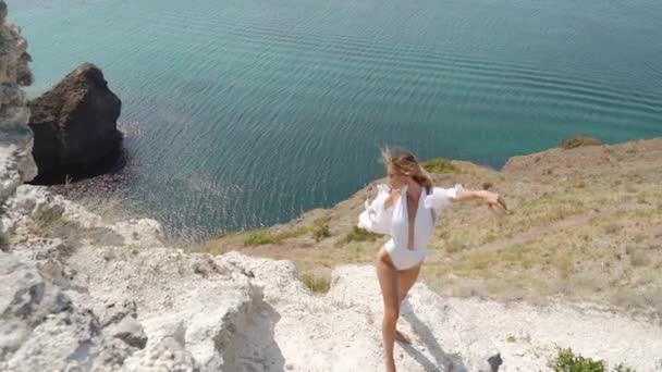 Молодая взрослая девушка позирует в платье у моря — стоковое видео