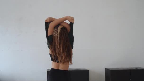 Молода дівчина танцює виразний стиль з рухом спритності в хореографічній студії — стокове відео