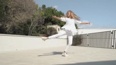 Junior girl dance and spin around in city